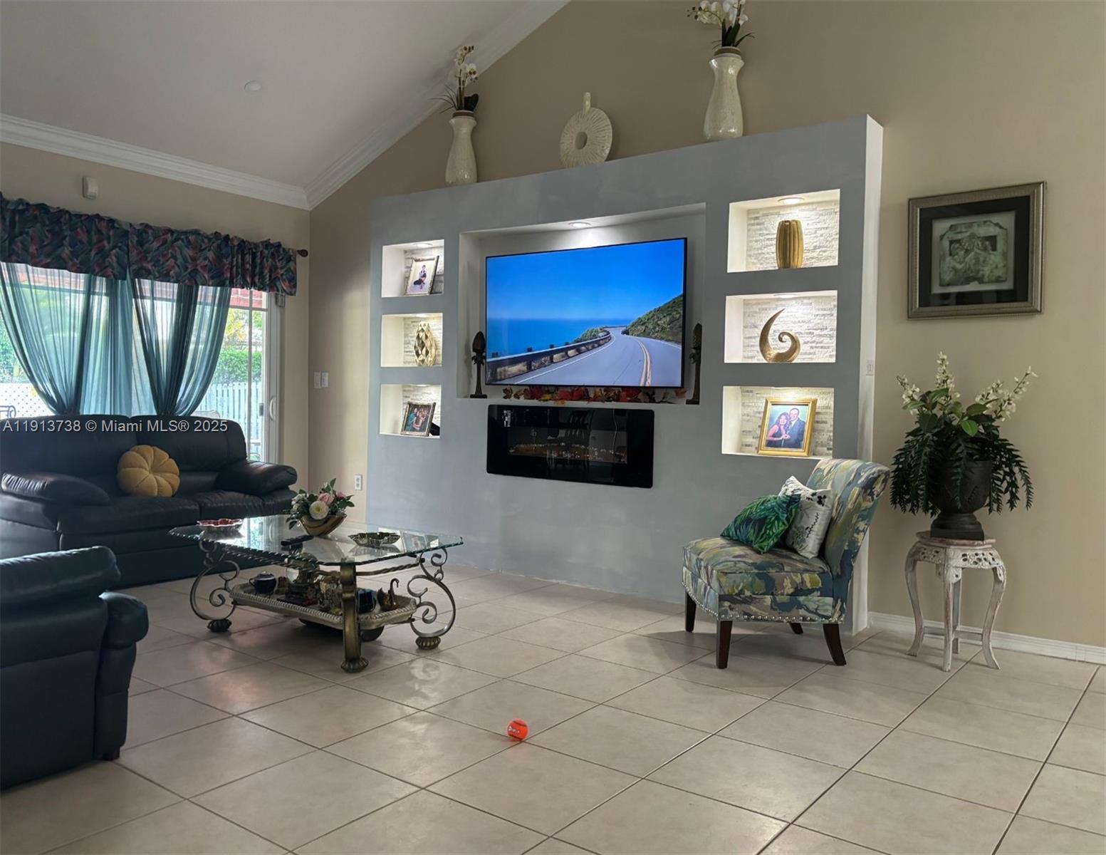 A living room features a large built-in media wall with a fireplace and tiled flooring — 15264 SW 43rd Ct, Miramar FL 33027, MIRAMAR, FL