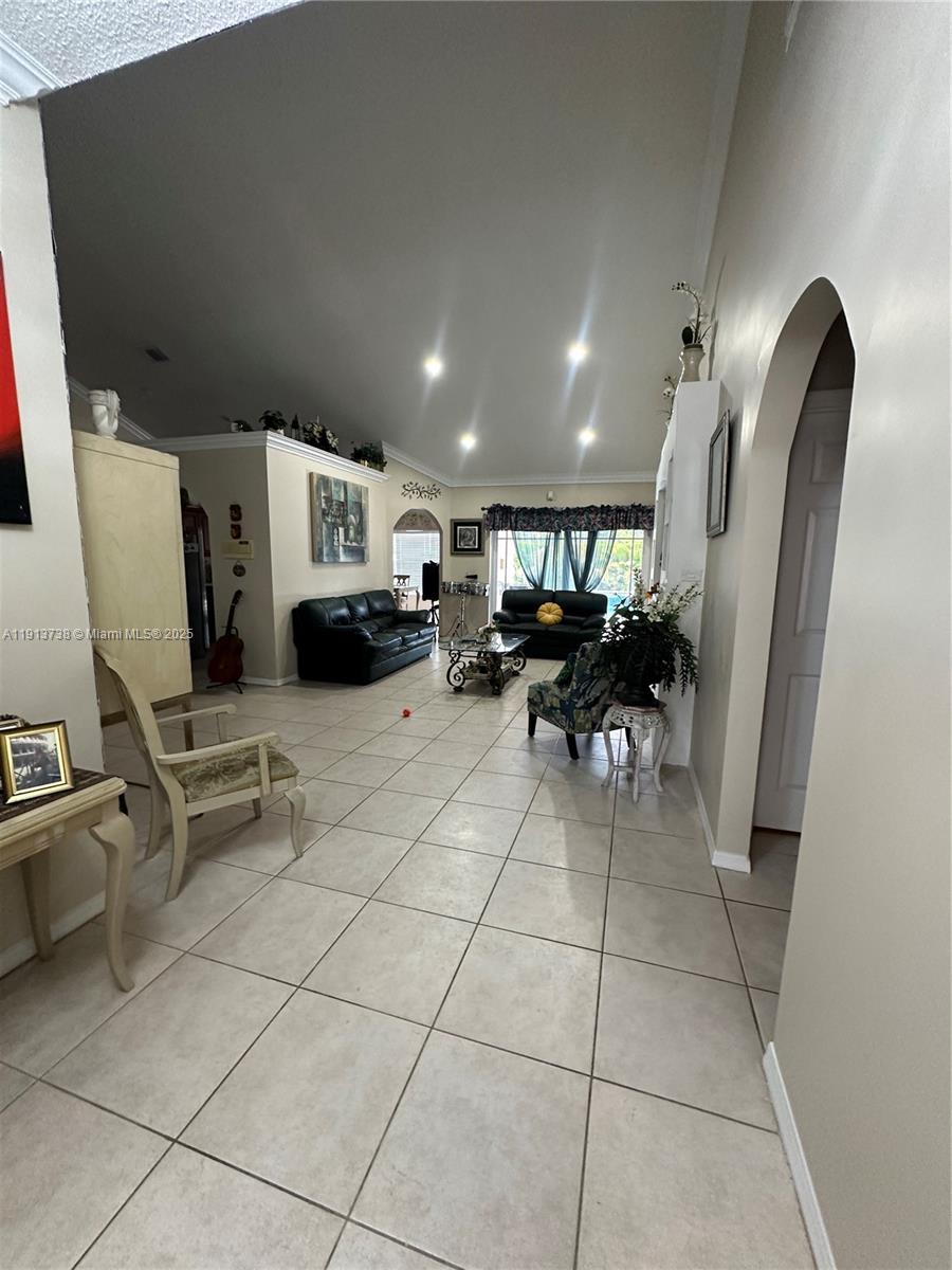 A spacious living room features vaulted ceilings, tile flooring, and two black leather sofas — 15264 SW 43rd Ct, Miramar FL 33027, MIRAMAR, FL