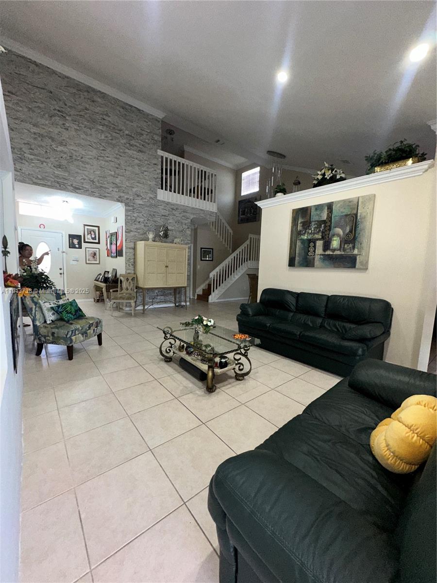 A living room features a stone-accented wall, a staircase, and two dark leather sofas — 15264 SW 43rd Ct, Miramar FL 33027, MIRAMAR, FL