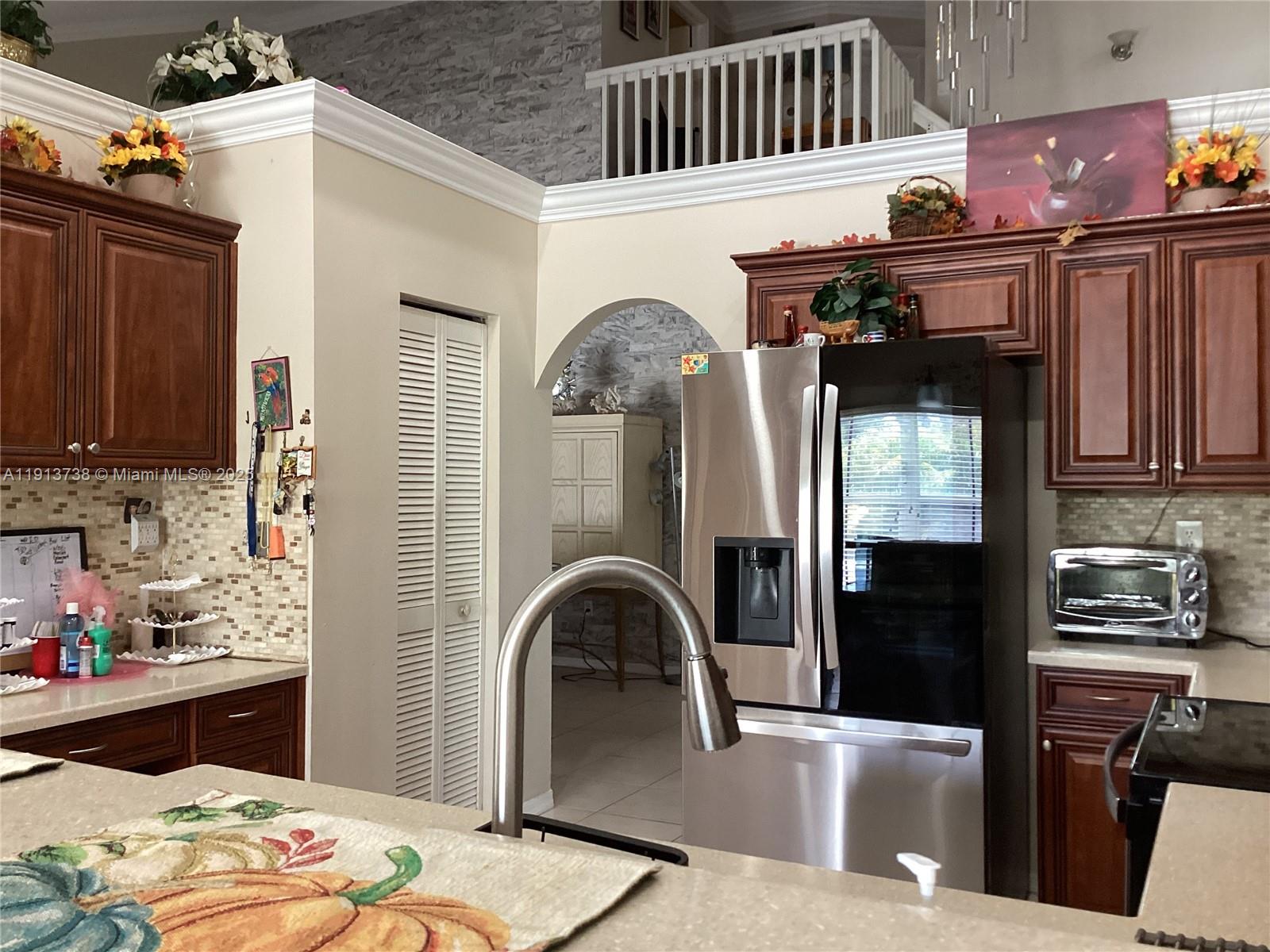 A kitchen features dark wood cabinetry, stainless steel appliances, and a central island — 15264 SW 43rd Ct, Miramar FL 33027, MIRAMAR, FL