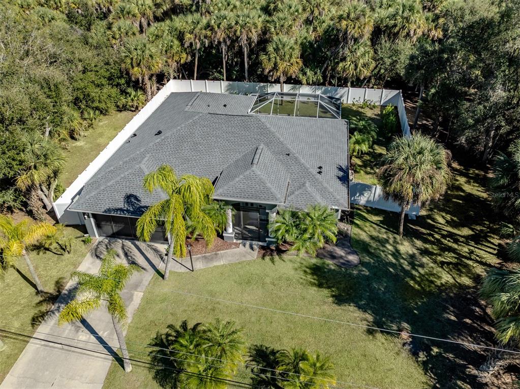 An aerial view of a single-story house with a gray roof and a screened-in pool — 5242 ABDELLA LANE, NORTH PORT, FL