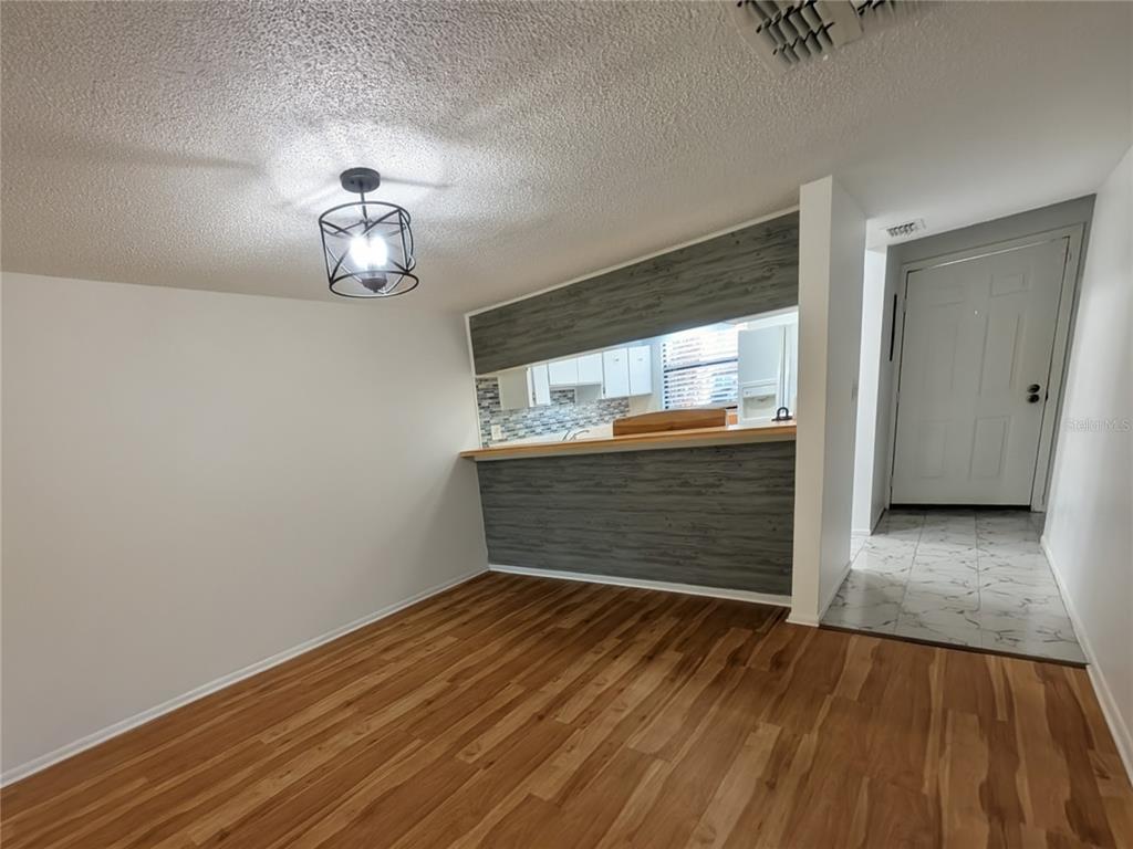 A living room features wood-look flooring, a ceiling fan, a mirrored wall, and sliding glass doors — 9209 SEMINOLE BOULEVARD UNIT 67, SEMINOLE, FL