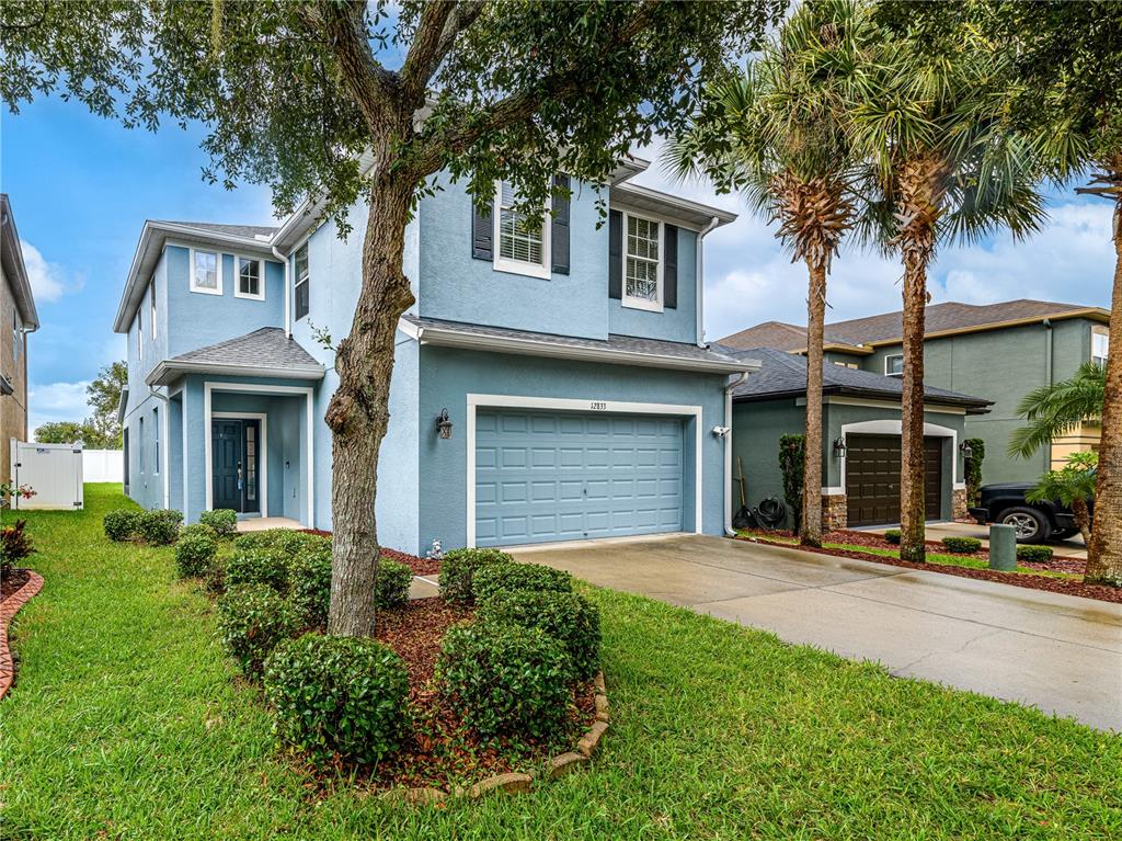 A two-story blue house with a two-car garage and a landscaped front yard — 12833 GENEVA GLADE DRIVE, RIVERVIEW, FL