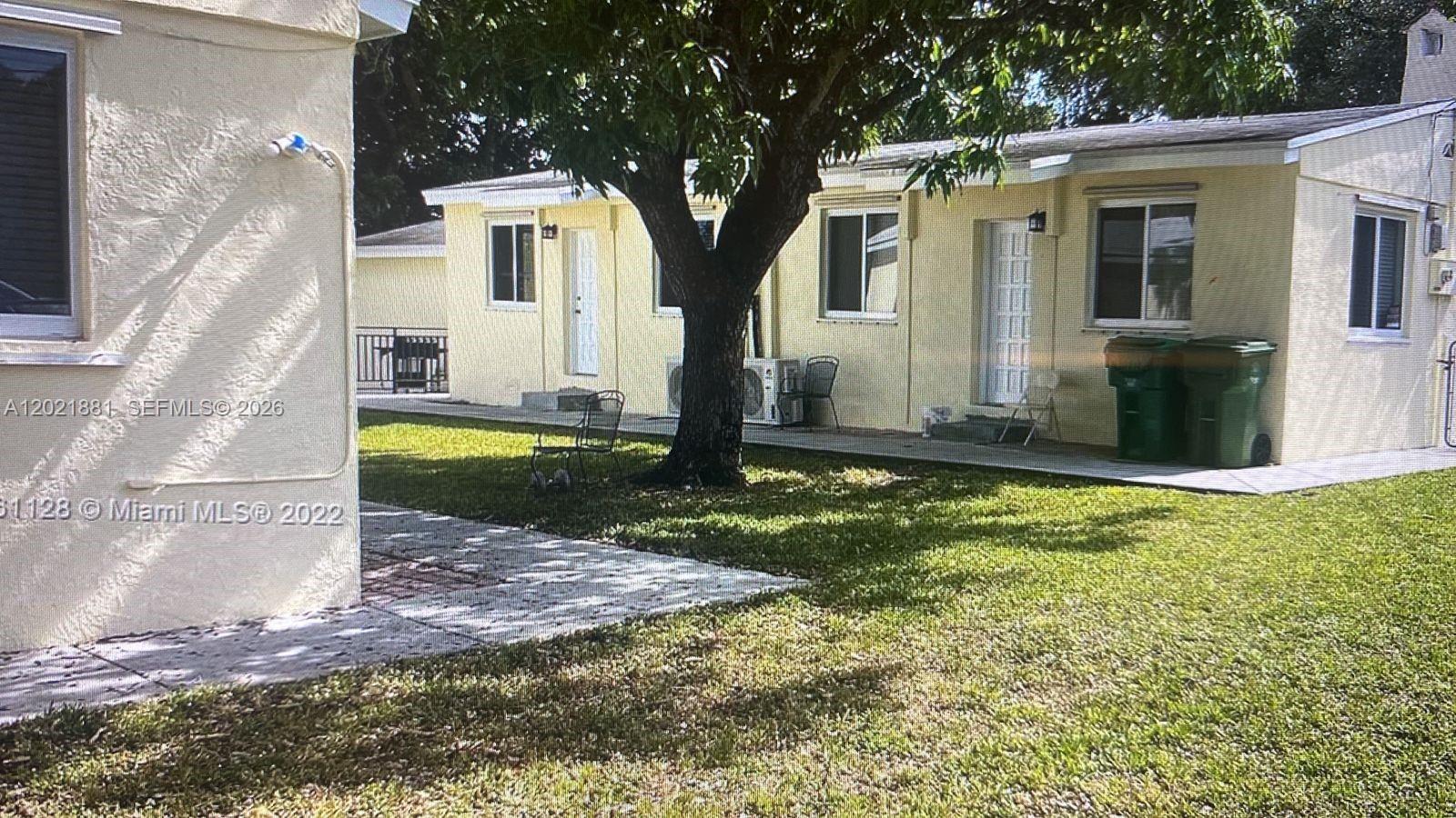 A yellow single-story building with multiple entrances and a large tree in the yard — 7637 NW 3rd Ave, Miami FL 33150, MIAMI, FL