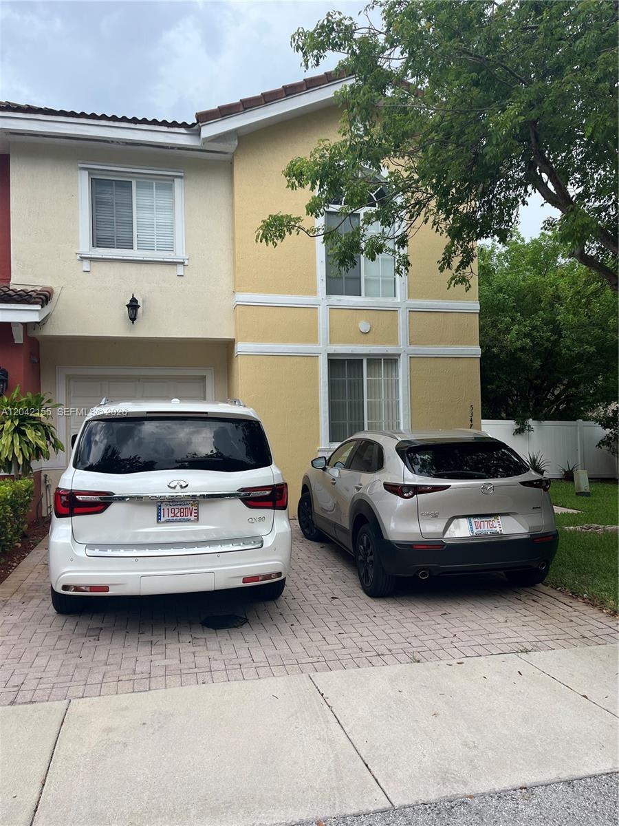 A two-story yellow stucco house with a paved driveway and two parked cars — 5347 SW 40th Ave # 5347, Dania Beach FL 33314, DANIA BEACH, FL