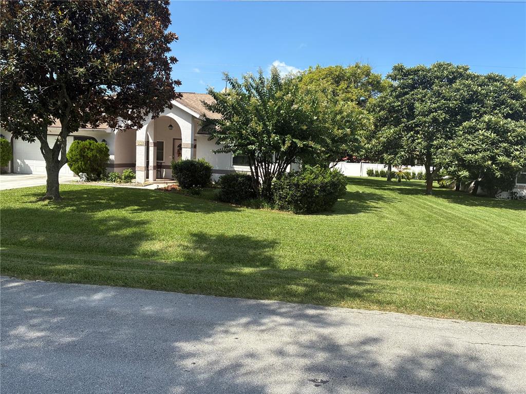 A single-story house with a white garage, arched entryway, and a large tree in front — 176 BREN MAR LANE, PALM COAST, FL