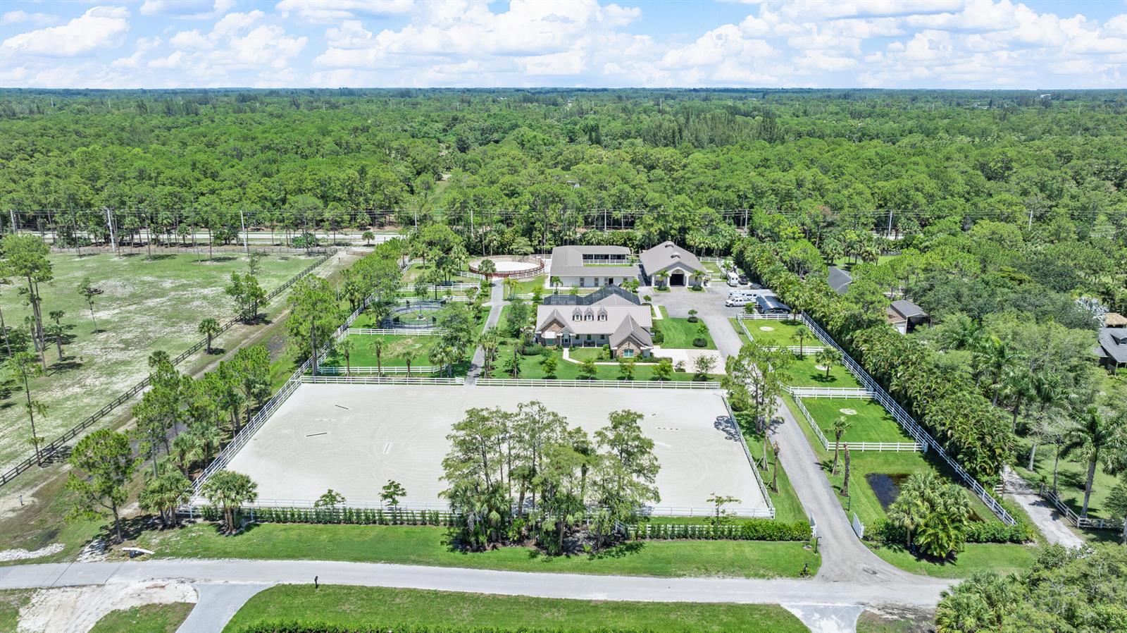 An aerial view shows a large equestrian property with a house, stables, and riding arena — 1464 Stallion Drive, Loxahatchee FL 33470, LOXAHATCHEE, FL
