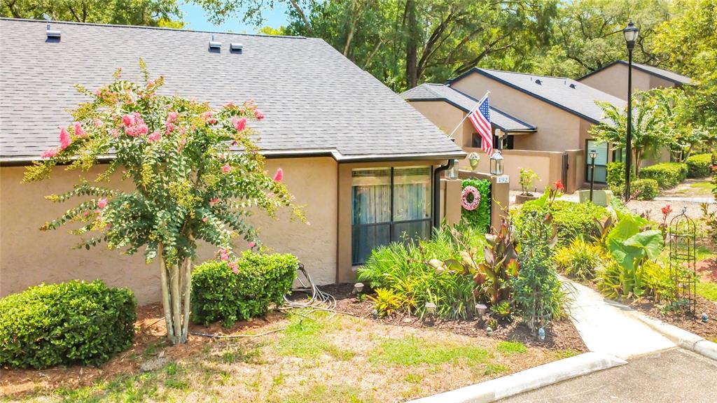 A tan house with a gray shingled roof and an American flag in the front yard — 940 DOUGLAS AVENUE UNIT 192, ALTAMONTE SPRINGS, FL