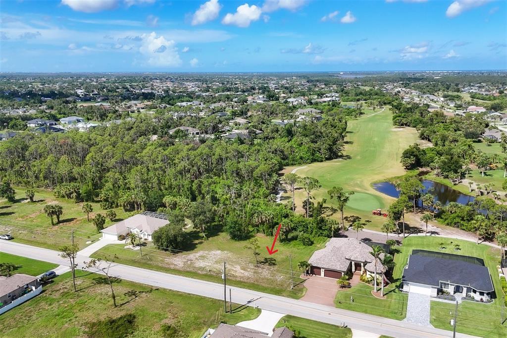 An aerial view shows a vacant residential lot situated between two houses near a golf course — 760 ROTONDA CIRCLE, ROTONDA WEST, FL