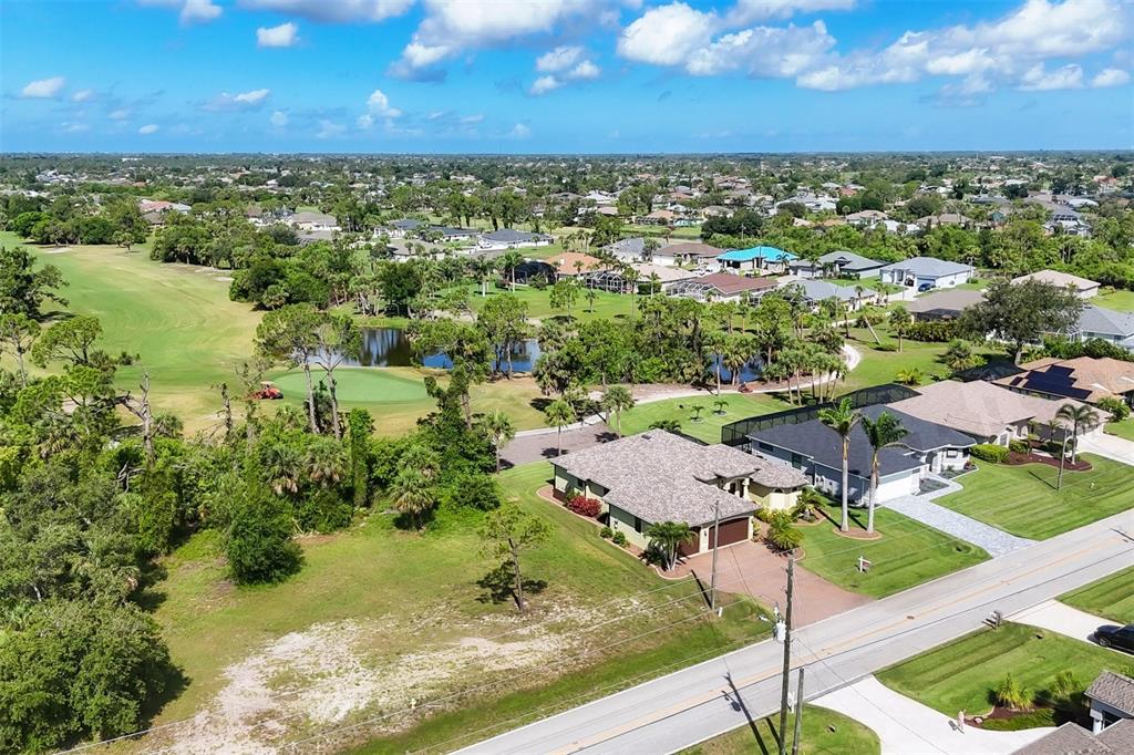 An aerial view shows a house with a garage situated next to a golf course — 760 ROTONDA CIRCLE, ROTONDA WEST, FL