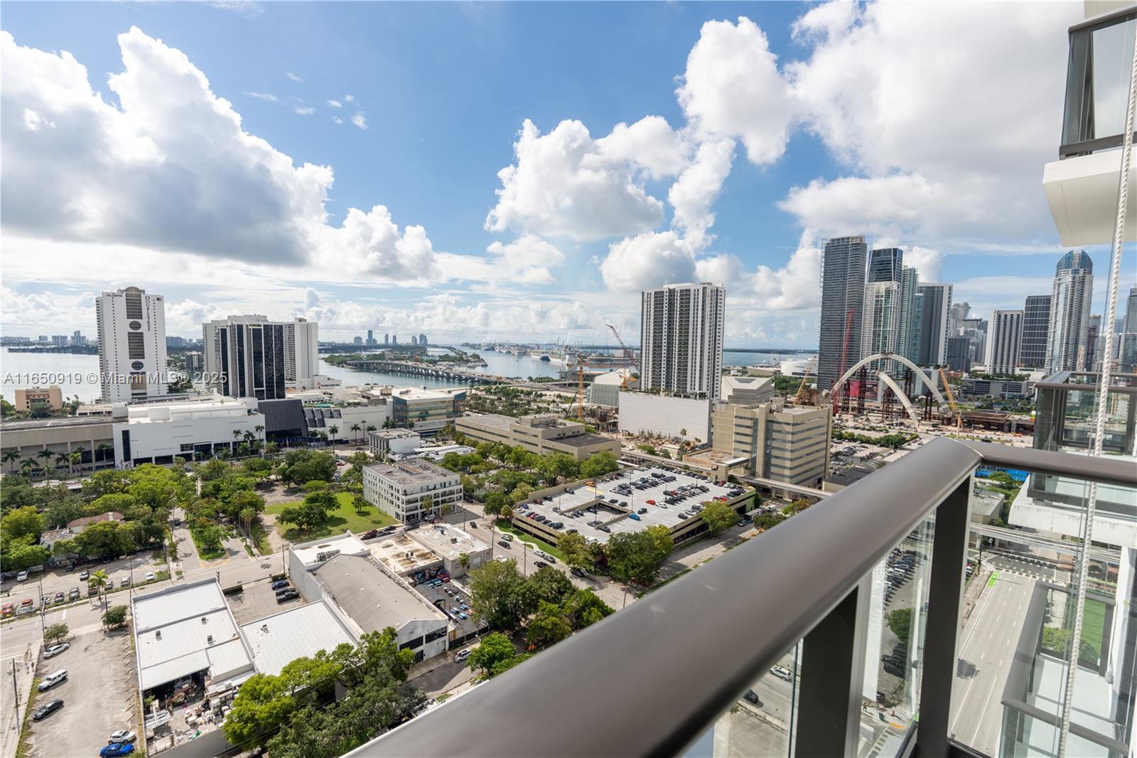 A high-angle view shows a city skyline, a bridge, and a parking lot from a balcony — 1642 NE 1st Ave # 2409, Miami FL 33132, MIAMI, FL