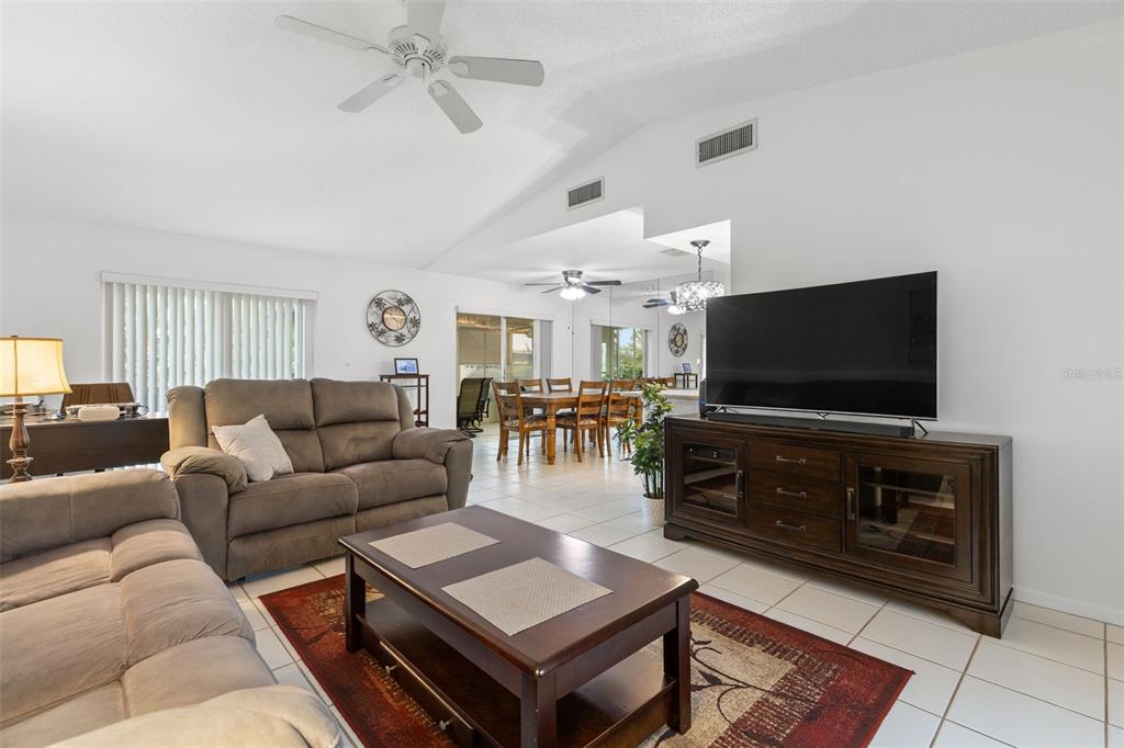 A living room features a brown sofa, a coffee table, and a television on a console — 3143 37TH LANE S UNIT B, ST PETERSBURG, FL