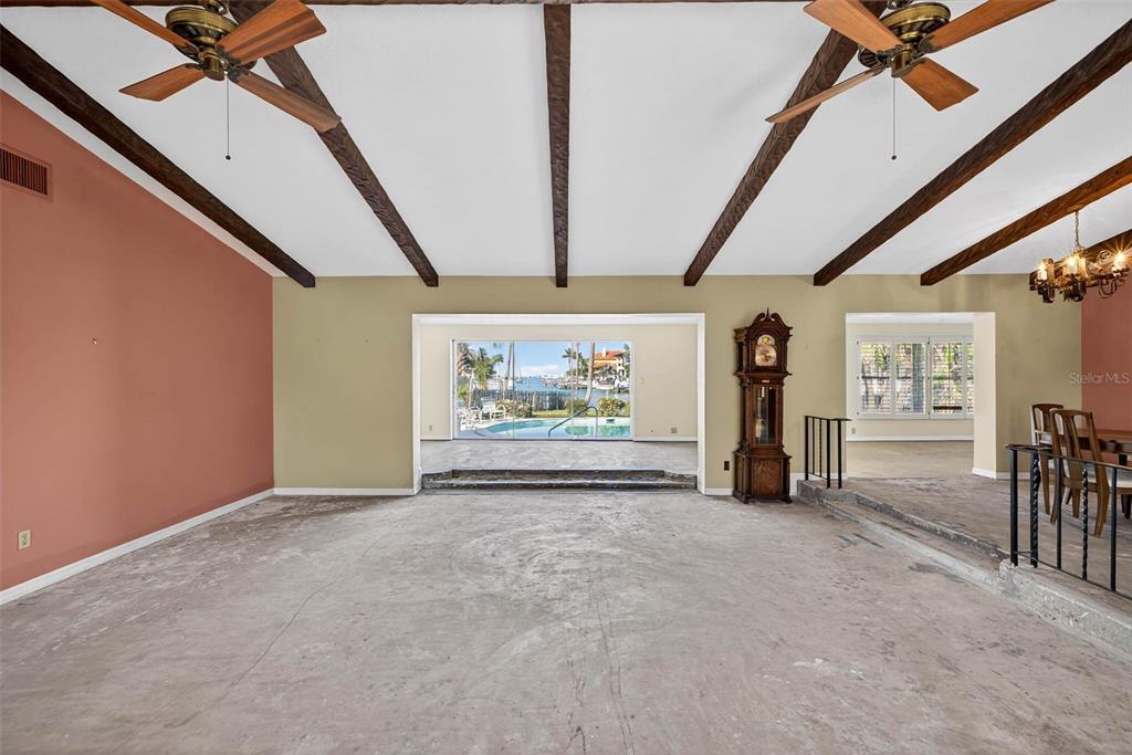 A living room with exposed ceiling beams, a grandfather clock, and a view of a pool — 3103 WEDGEWOOD DRIVE, BELLEAIR BEACH, FL