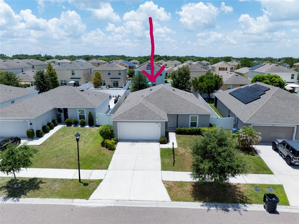 An aerial view shows a single-story suburban house with a gray roof and driveway — 10205 CARP HOLLOW ROAD, SUN CITY CENTER, FL