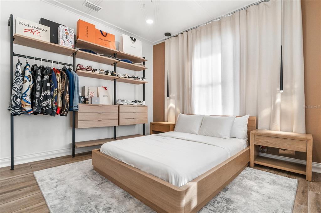 A bedroom features a platform bed, light wood furniture, and an open-concept wall closet system — 3513 N 15TH STREET, TAMPA, FL