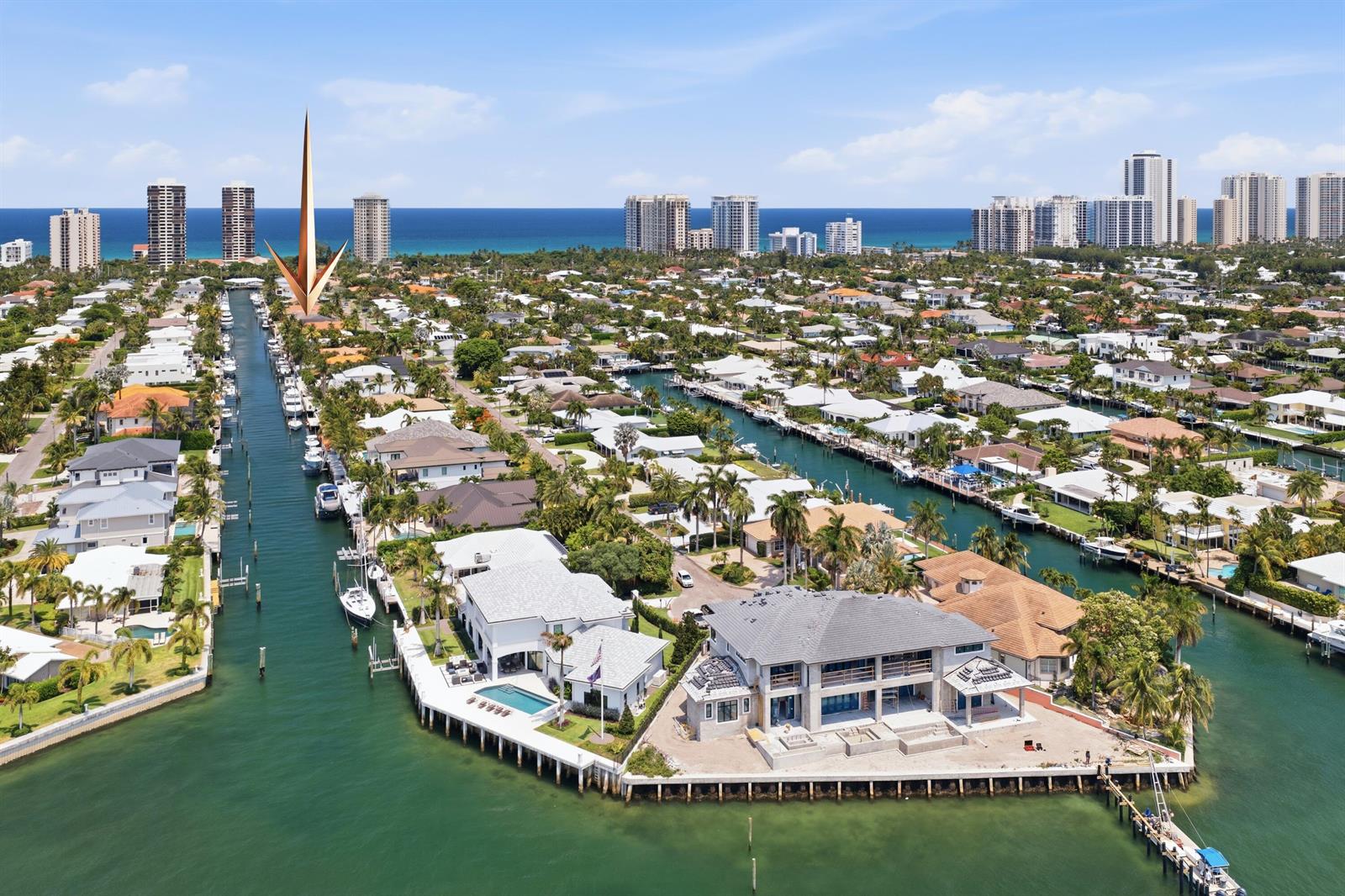 An aerial view shows waterfront luxury homes along canals with boats and a distant ocean — 1170 Fairview Lane, Singer Island FL 33404, SINGER ISLAND, FL