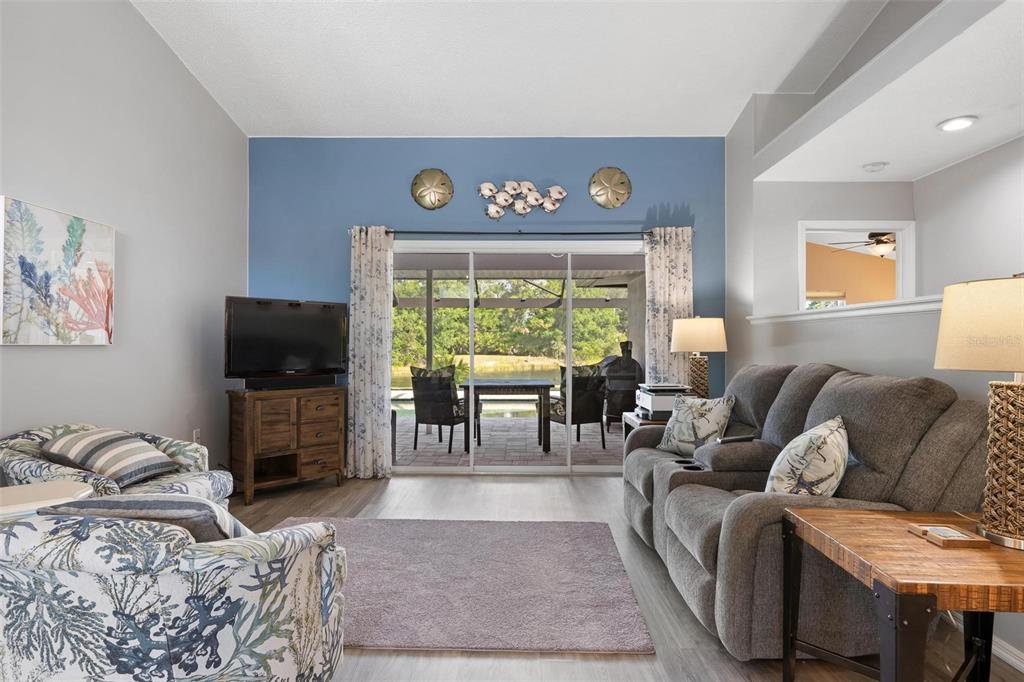 A living room features a blue accent wall, sliding glass doors, and a patio view — 5009 SOUTHERN PINE CIRCLE, VENICE, FL
