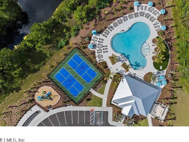 An aerial view shows a swimming pool, tennis courts, a playground, and a parking lot — 59 ARARAT DRIVE, PALM COAST, FL
