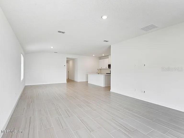 An open-concept living area features white walls, recessed lighting, and light gray tile flooring — 59 ARARAT DRIVE, PALM COAST, FL