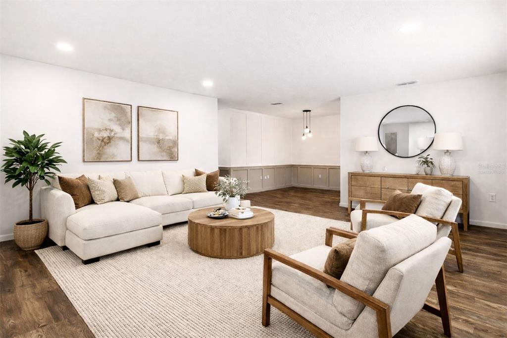 A living room features a white sectional sofa, two armchairs, and wood-paneled accent walls — 22632 SE HAWTHORNE ROAD, HAWTHORNE, FL