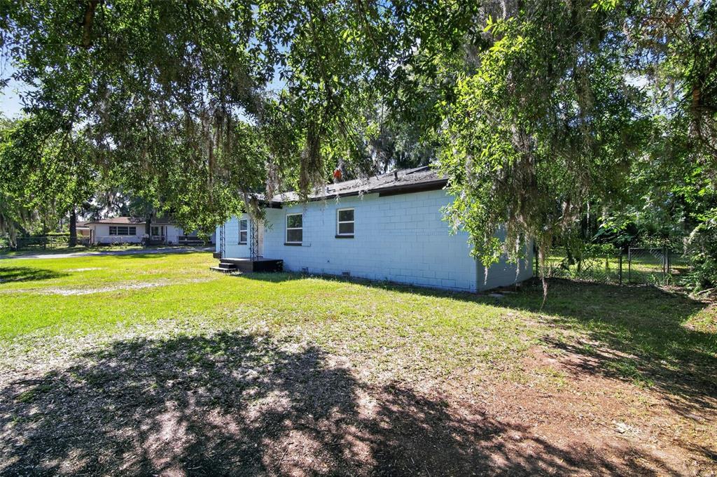 A light blue concrete block house sits on a grassy lot under large oak trees — 1308 SW 5TH STREET, OCALA, FL