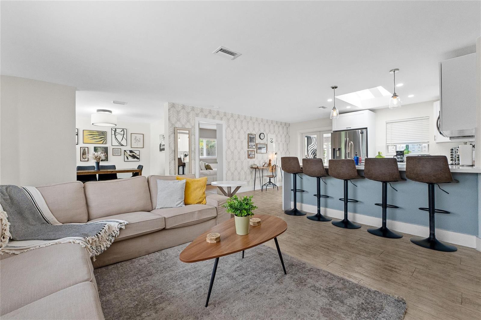 A living room with a sectional sofa flows into a kitchen with a breakfast bar — 2621 NE 20th Street, Pompano Beach FL 33064, POMPANO BEACH, FL