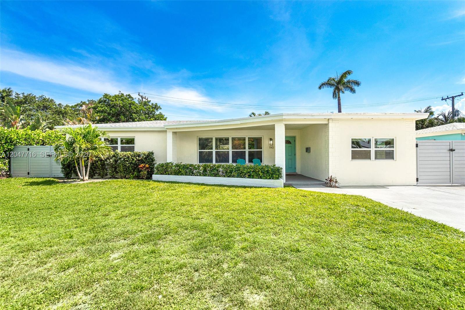 A single-story white house features a turquoise front door, a large lawn, and palm trees — 190 NE 21st St, Boca Raton FL 33431, BOCA RATON, FL