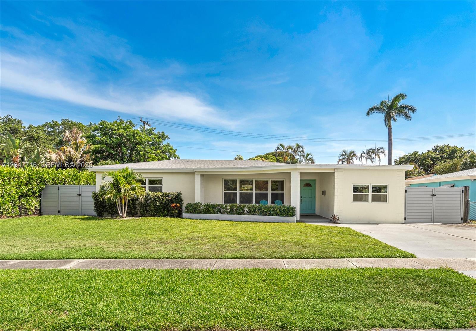 A single-story house with a light-colored exterior, a turquoise front door, and a grassy lawn — 190 NE 21st St, Boca Raton FL 33431, BOCA RATON, FL
