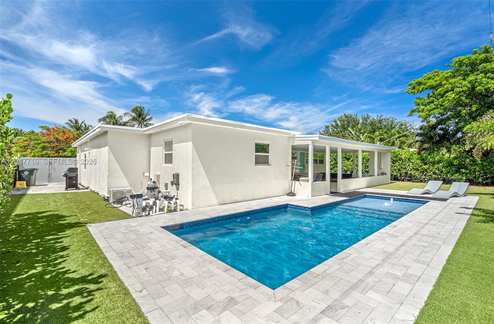 A rectangular swimming pool sits in a backyard with a patio and a white house — 190 NE 21st St, Boca Raton FL 33431, BOCA RATON, FL