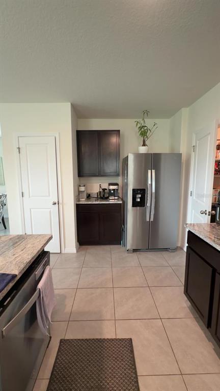A kitchen features dark wood cabinets, stainless steel appliances, and light-colored tile flooring — 35665 SUNFLOWER HILL DRIVE, ZEPHYRHILLS, FL
