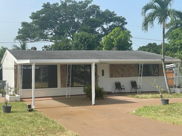 A single-story house features a white exterior, a covered carport, and a front lawn — 6141 Wiley St, Hollywood FL 33023, HOLLYWOOD, FL