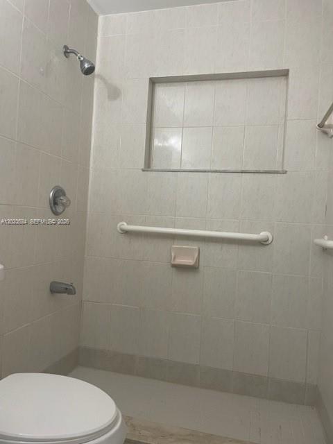 A bathroom shower area features white tiled walls, a grab bar, and a recessed shelf — 6141 Wiley St, Hollywood FL 33023, HOLLYWOOD, FL