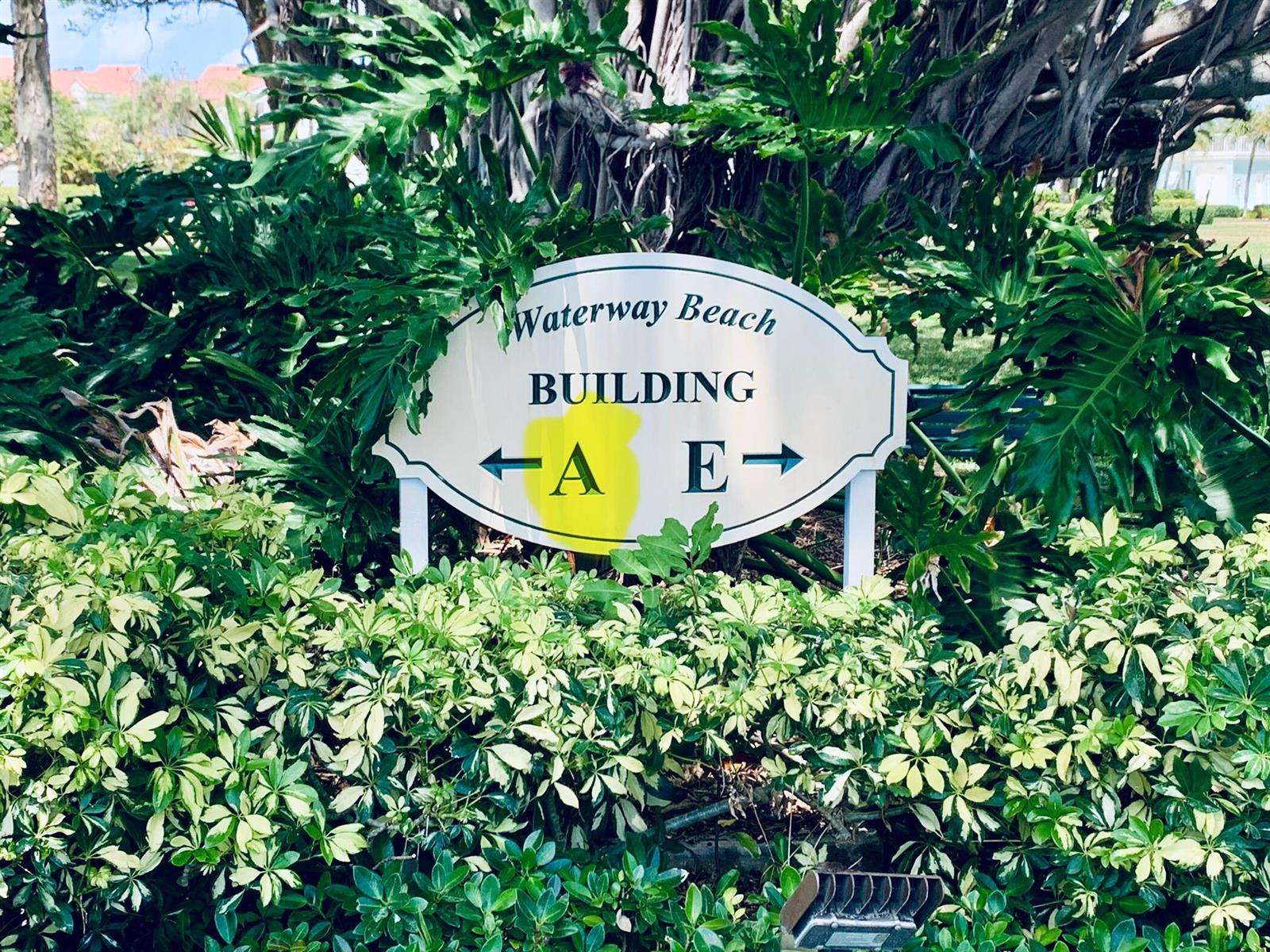 A sign for Waterway Beach points toward buildings A and E amidst lush green foliage — 100 Waterway Road # A304, Tequesta FL 33469, TEQUESTA, FL
