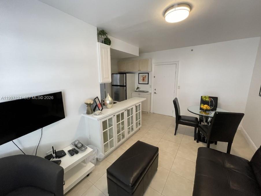 A living room and dining area feature white cabinets, a glass table, and tile flooring — 335 Ocean Dr # 214, Miami Beach FL 33139, MIAMI BEACH, FL