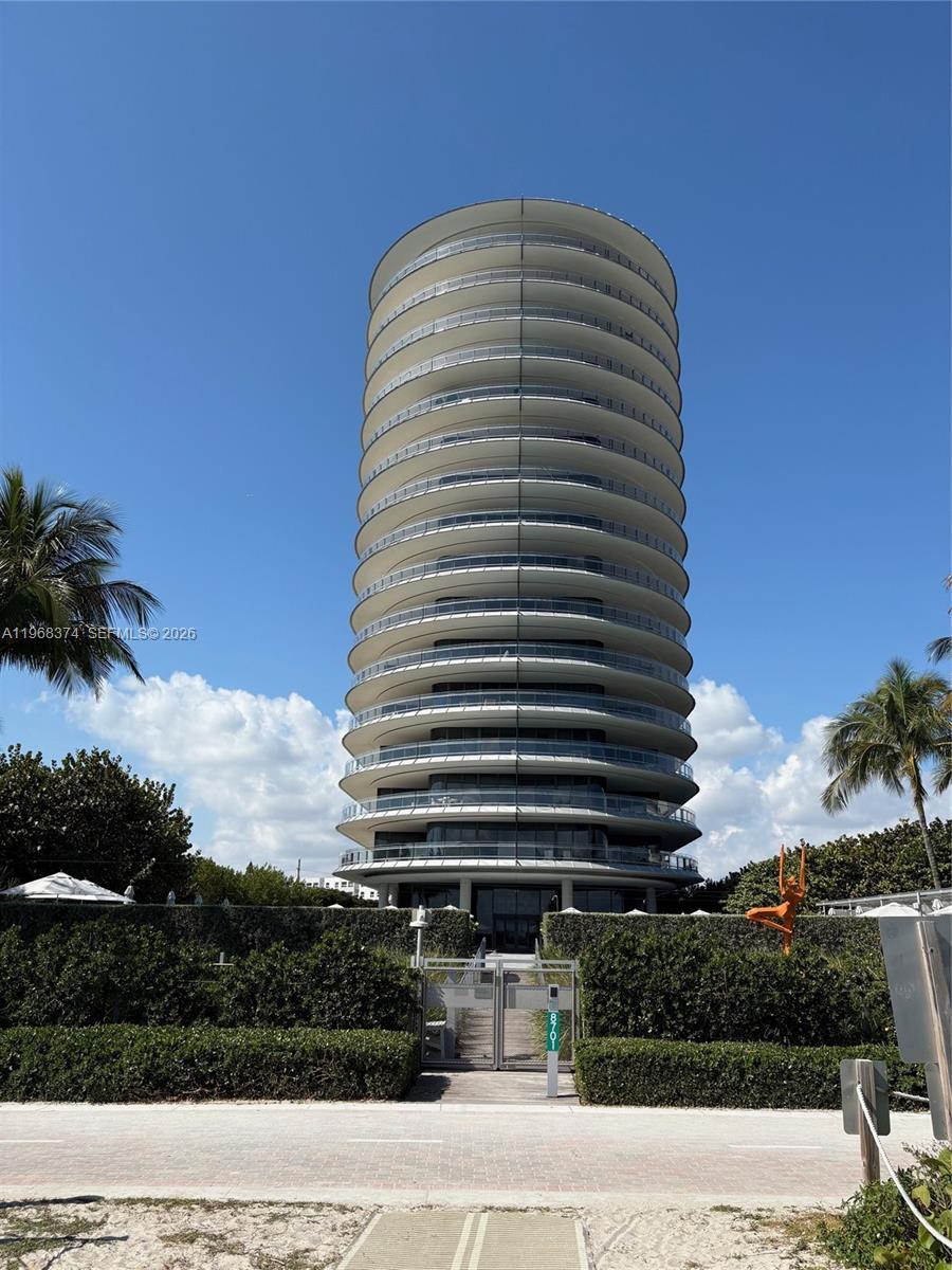 A tall, cylindrical residential tower with wrap-around balconies stands behind a gated entrance — 8701 Collins Ave # 803, Miami Beach FL 33154, MIAMI BEACH, FL