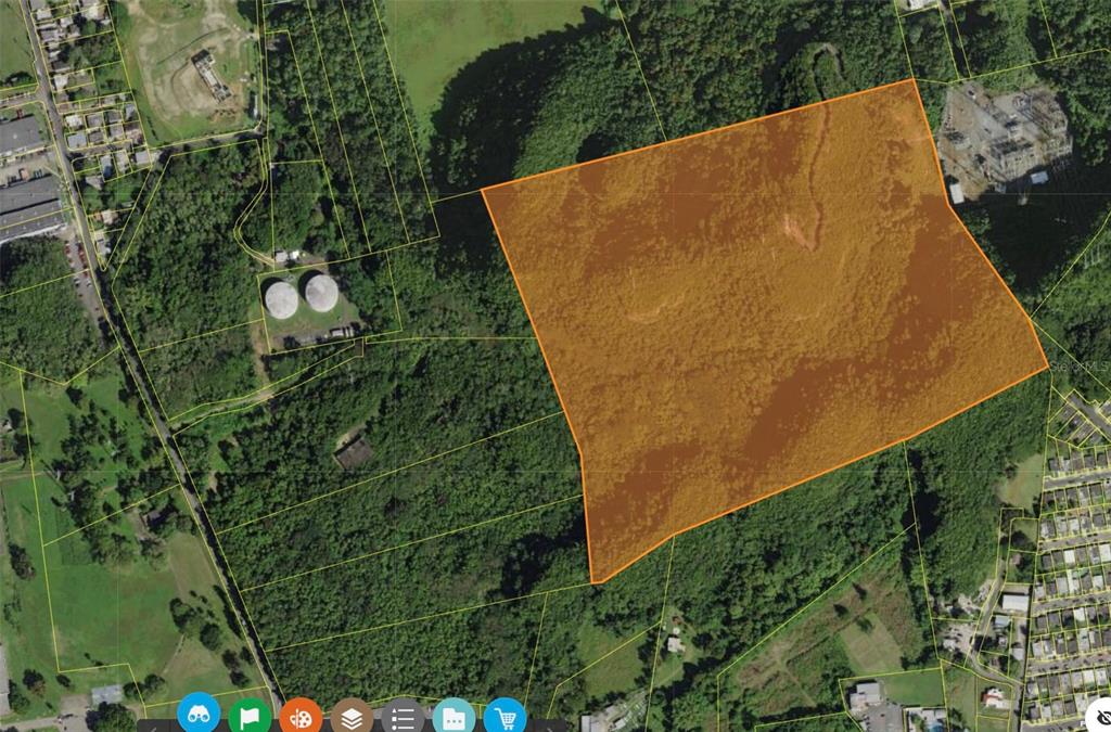 An aerial map shows a large, orange-highlighted plot of land surrounded by trees and buildings — 1 PR-686 KM 1.2 INTERIOR, MANATI, PR