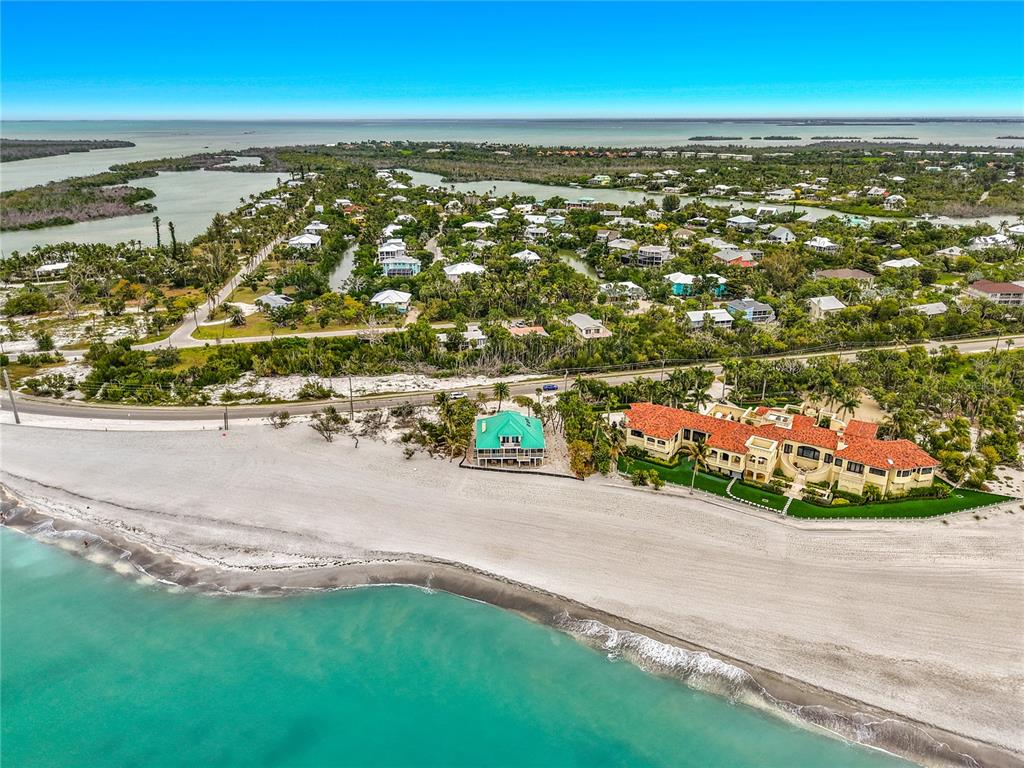 An aerial view shows two beachfront houses separated by a road from a coastal neighborhood — 6351 SANIBEL CAPTIVA ROAD, SANIBEL, FL