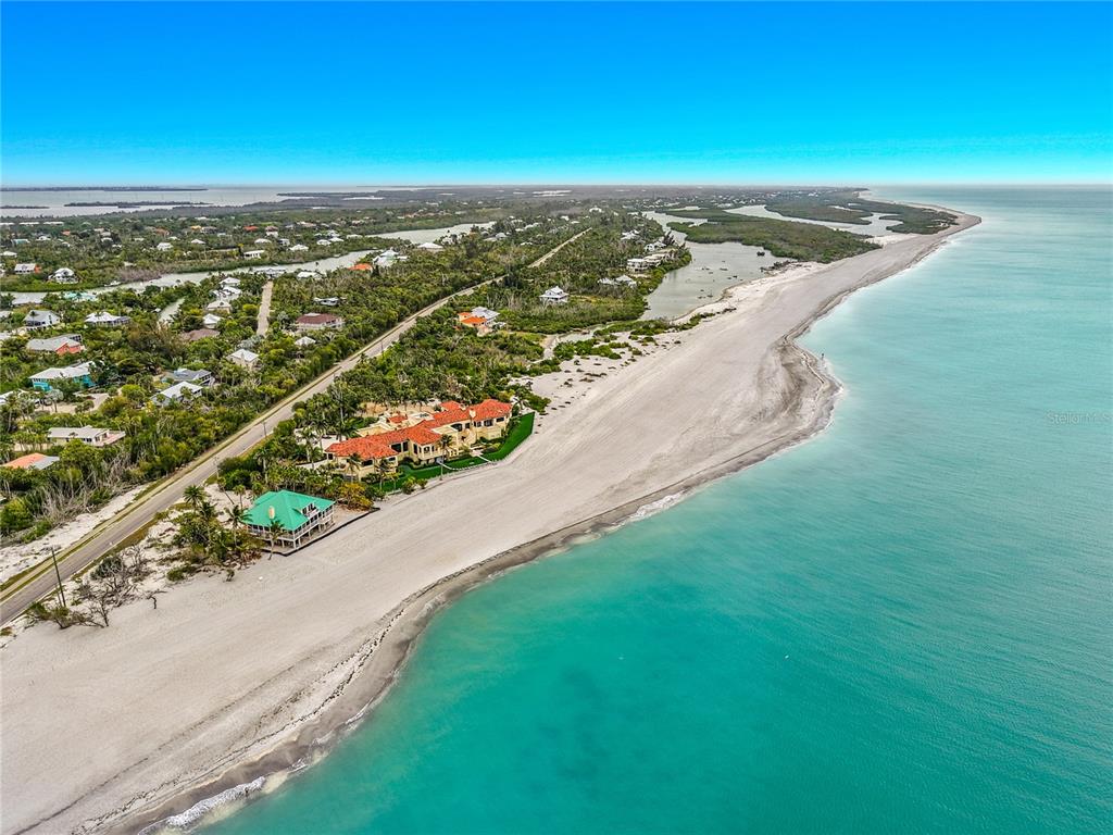 An aerial view shows a beachfront property with a large house and a green-roofed structure — 6351 SANIBEL CAPTIVA ROAD, SANIBEL, FL
