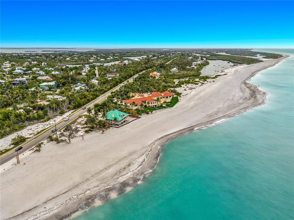 An aerial view shows a coastal road, sandy beach, and several houses along the shore — 6351 SANIBEL CAPTIVA ROAD, SANIBEL, FL