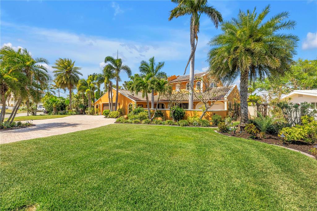 A swimming pool overlooks a wooden deck and boat dock on a canal — 3945 POINSETTIA DRIVE, ST PETE BEACH, FL