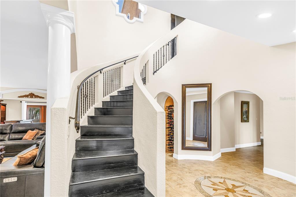 A yellow house with a brown garage door and a paved driveway surrounded by palm trees — 3945 POINSETTIA DRIVE, ST PETE BEACH, FL