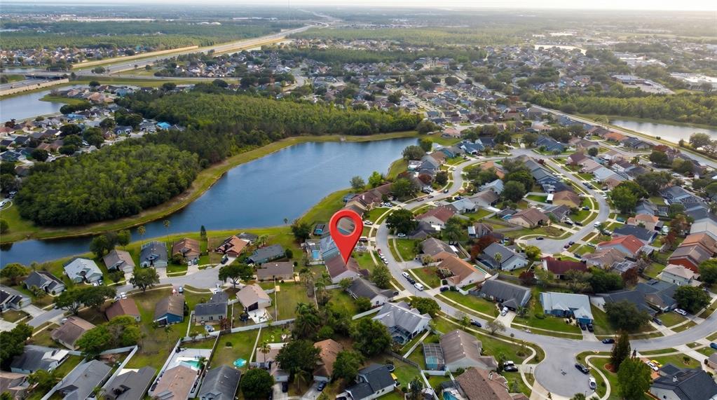 An aerial view shows a residential neighborhood with a lake and a red location pin — 2003 TIPTREE CIRCLE, ORLANDO, FL