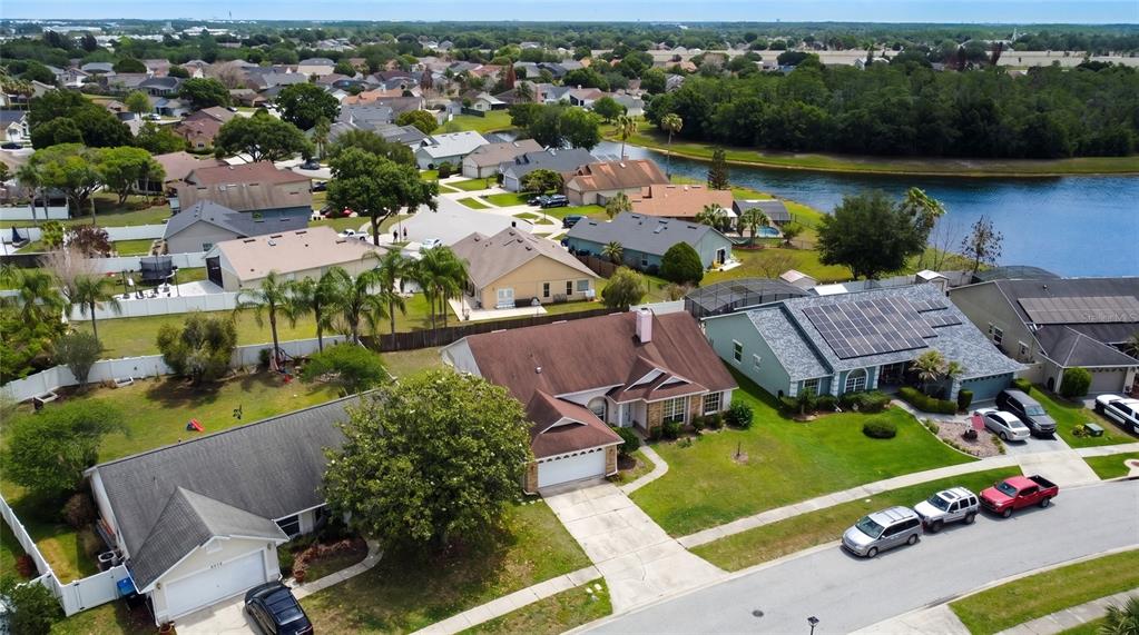 An aerial view shows suburban houses with driveways, lawns, and a nearby lake — 2003 TIPTREE CIRCLE, ORLANDO, FL