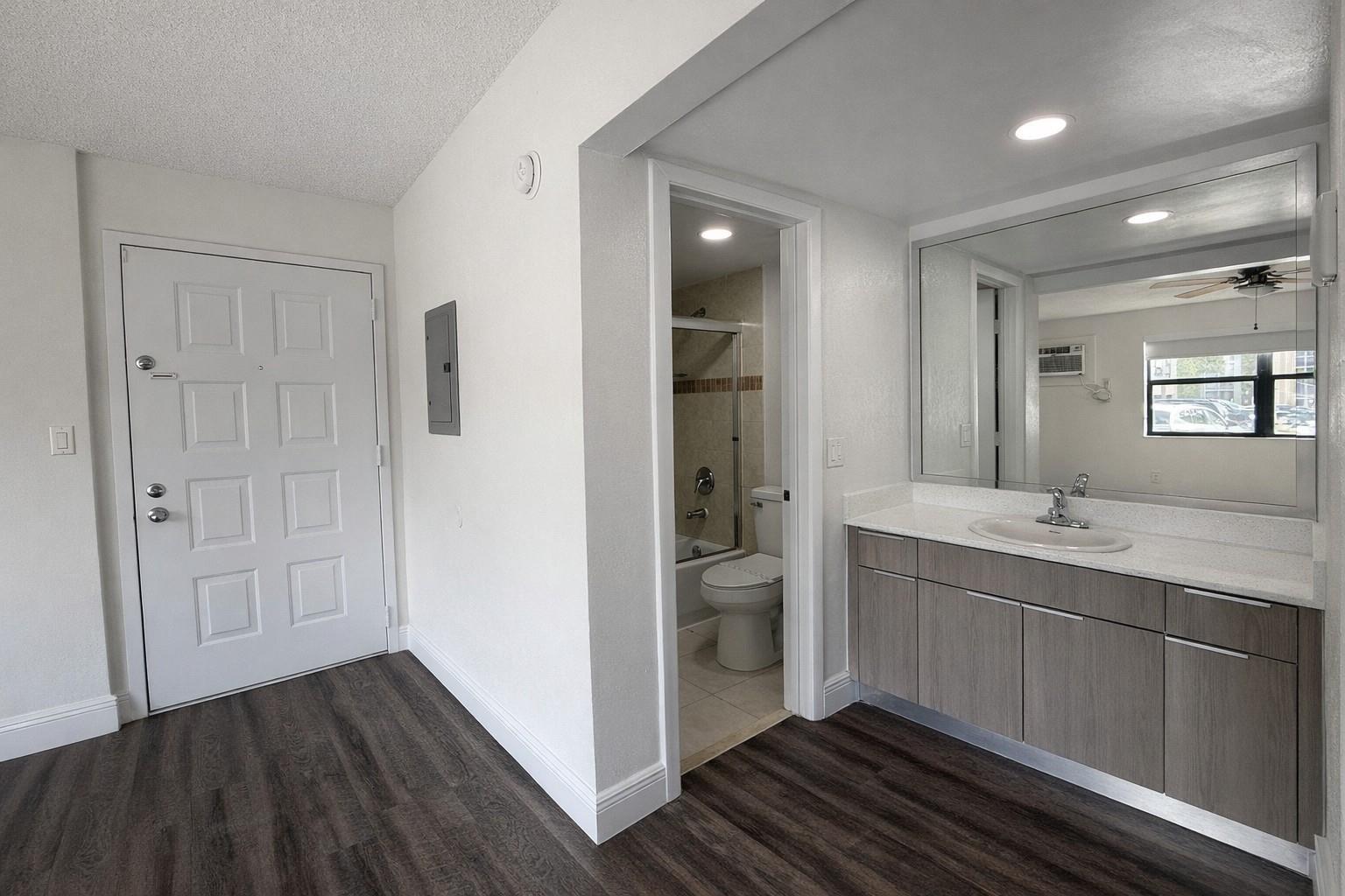 A bathroom vanity with a grey cabinet and white countertop sits next to a doorway — 17350 NW 68th Avenue # 402a, Hialeah FL 33015, HIALEAH, FL