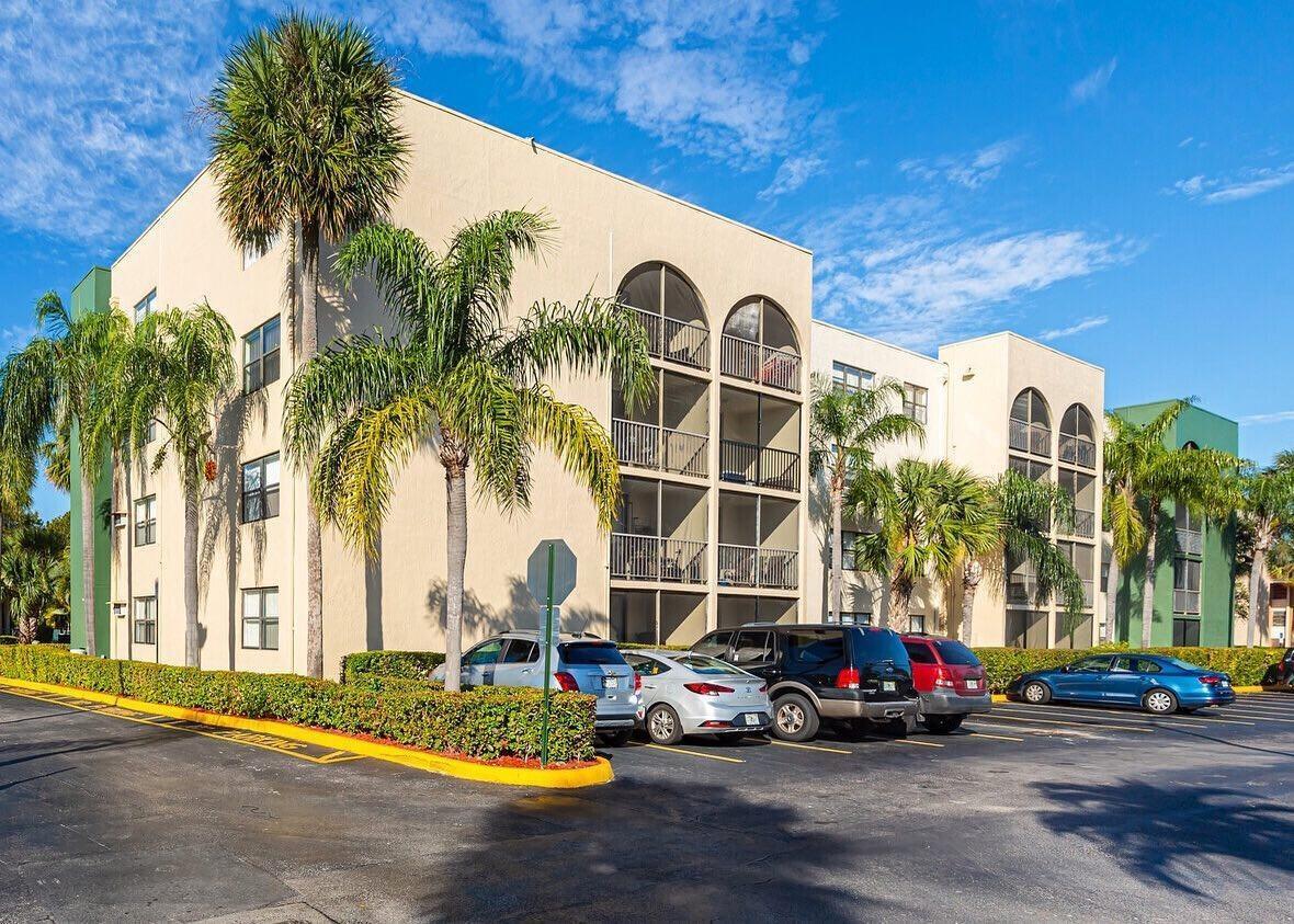 A multi-story apartment building with arched balconies and palm trees in a parking lot — 17350 NW 68th Avenue # 402a, Hialeah FL 33015, HIALEAH, FL
