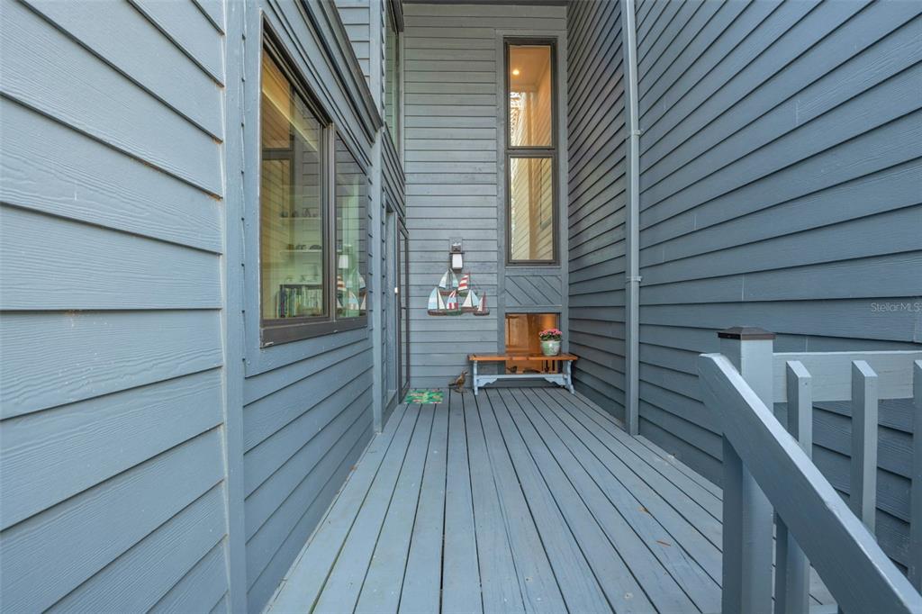 A blue-sided exterior wall features a large window looking into a kitchen and a door — 12 MARINER DRIVE UNIT 12, TARPON SPRINGS, FL