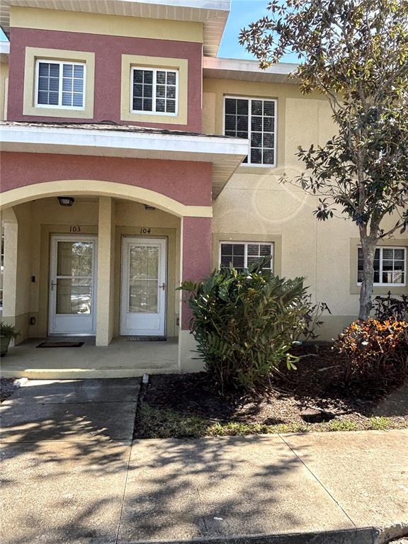 The exterior of a two-story building features two ground-level entry doors numbered 103 and 104 — 3825 45TH TERRACE W UNIT 104, BRADENTON, FL