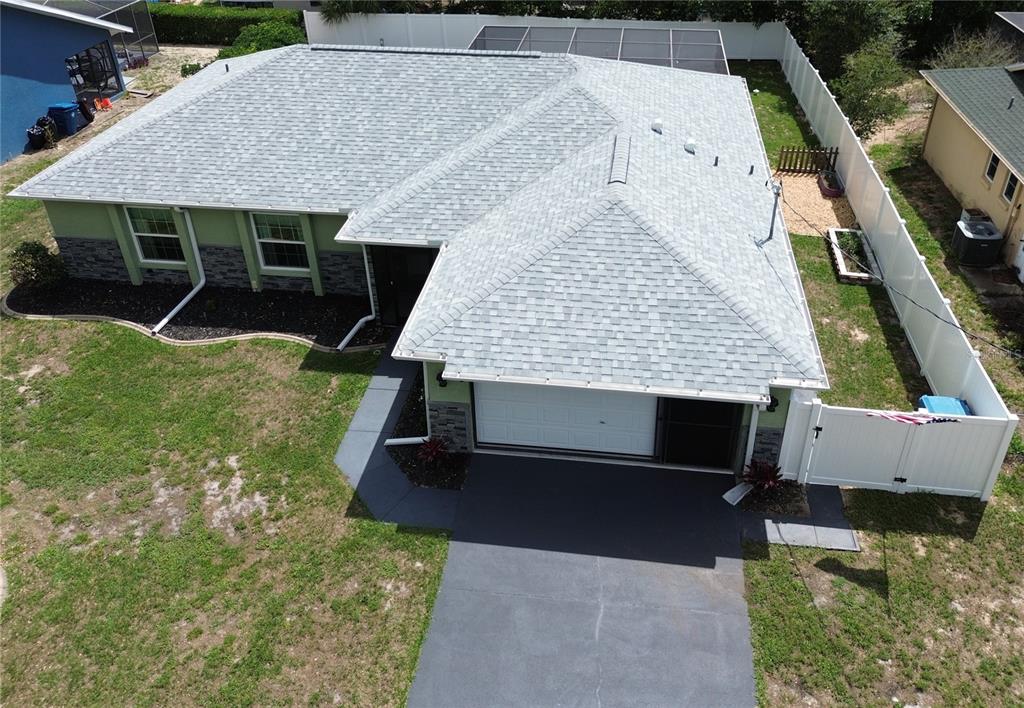 An aerial view of a single-story house with a gray shingled roof and driveway — 11382 PICKFORD STREET, SPRING HILL, FL