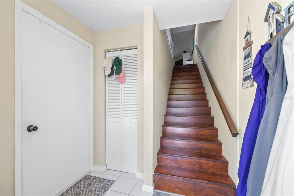 An entryway features a white door, a louvered closet, and a wooden staircase — 751 PINELLAS BAYWAY S UNIT 208, TIERRA VERDE, FL