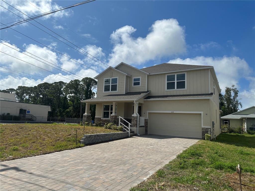 A two-story house with a beige exterior, a paved driveway, and a two-car garage — 246 BURNEY RD, OSPREY, FL